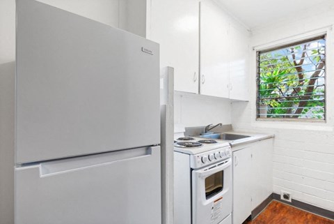 A white fridge and stove in a small kitchen.